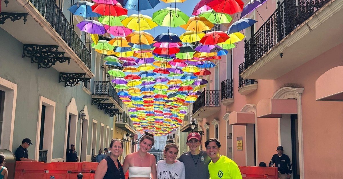 Small tour group under the colorful umbrella installation on Calle Fortaleza in Old San Juan