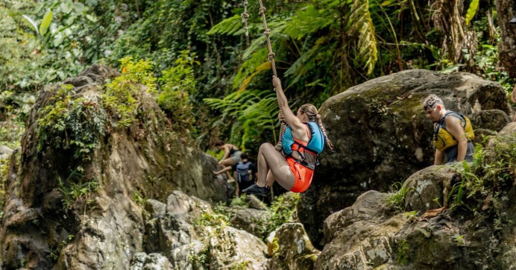Visitor on a rope swing in the dense rainforest of El Yunque National Forest, Puerto Rico